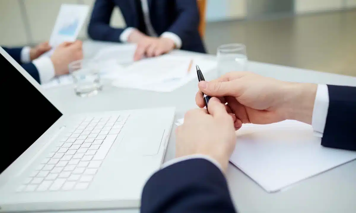 Reunião corporativa com executivos analisando documentos e estratégias de negócios